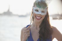 Retrato de mulher sorridente usando máscara à beira-mar em Veneza — Fotografia de Stock