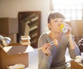 Woman drinking soda and eating sushi in new home — Stock Photo