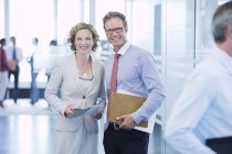 Business people smiling in office hallway — Stock Photo