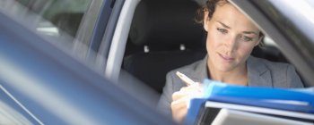 Businesswoman working in car — Stock Photo