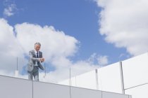 Portrait d'homme d'affaires confiant avec les mains serrées sur le balcon — Photo de stock