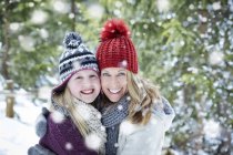 Мать и дочь обнимаются в снегу — стоковое фото