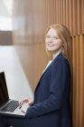 Портрет улыбающейся деловой женщины с помощью ноутбука — стоковое фото