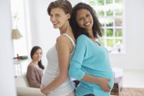 Беременные женщины улыбаются вместе — стоковое фото