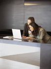 Бізнес-леді, використовуючи ноутбук у вестибюлі в сучасному офісі — стокове фото