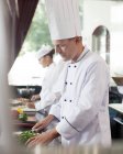 Chef chopping vegetables in restaurant kitchen — Stock Photo