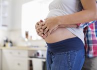 Homme tenant enceinte girlfriends ventre — Photo de stock