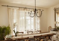 Chandelier over dining room table — Stock Photo
