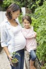 Ragazza e madre incinta giardinaggio insieme — Foto stock