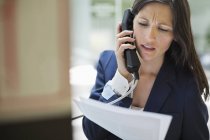 Femme d'affaires parlant au téléphone au bureau moderne — Photo de stock