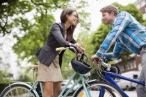 Пара штовхає велосипеди на міську вулицю — стокове фото