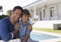 Père et fils souriant devant la maison — Photo de stock