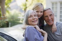 Älteres Paar umarmt Enkelin — Stockfoto