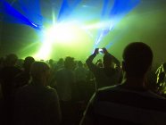 Силуэт толпы перед освещенной сценой на музыкальном фестивале — стоковое фото