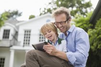Батько і син використовують цифровий планшет на відкритому повітрі — стокове фото
