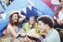 Friends hanging out at tent at music festival — Stock Photo