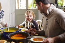 Father and daughter eating together at table — Stock Photo