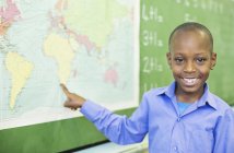 Studente afroamericano che utilizza la mappa del mondo in classe — Foto stock