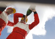 Racer drinking champagne on track — Stock Photo