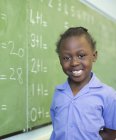 Étudiant afro-américain souriant au tableau noir — Photo de stock