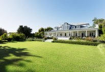Luxury house facing sunny lawn — Stock Photo