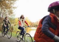 Family riding bicycles together in park — Stock Photo