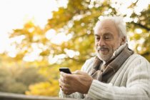 Взрослый мужчина использует мобильный телефон на открытом воздухе — стоковое фото