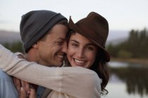 Закрыть портрет счастливой пары, обнимающейся на берегу озера — стоковое фото