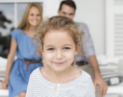 Крупним планом дівчина усміхнене обличчя проти батьків на задньому плані — стокове фото