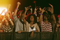 I fan con i telefoni della fotocamera applaudono al festival musicale — Foto stock