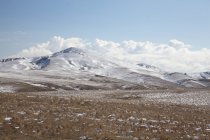 Облака над холмами в снежном пейзаже — стоковое фото