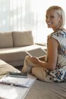 Businesswoman using tablet computer on sofa — Stock Photo