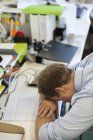 Бізнесмен спить голову на столі в сучасному офісі — стокове фото