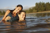 Портрет улыбающейся пары, купающейся в озере — стоковое фото