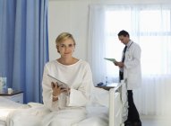 Пацієнт, який використовує планшетний комп'ютер у лікарняній кімнаті — стокове фото