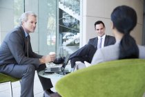 Geschäftsleute treffen sich in der Lobby eines modernen Büros — Stockfoto