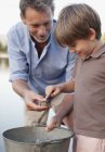 Grandfather and grandson with frog and bucket — Stock Photo