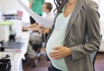 Embarazada mujer de negocios trabajando en la oficina - foto de stock