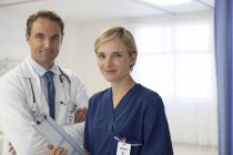 Médico y enfermera sonriendo en el hospital moderno - foto de stock