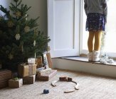 Niña con árbol de Navidad y regalos - foto de stock