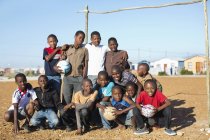 Meninos africanos segurando bolas de futebol no campo de sujeira — Fotografia de Stock