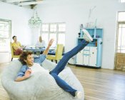 Man jumping into beanbag chair at home — Stock Photo