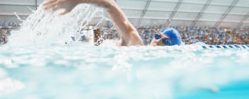Swimmer racing in pool water — Stock Photo
