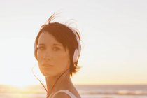 Close up retrato de mulher confiante usando fones de ouvido na praia — Fotografia de Stock