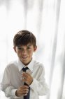 Улыбающийся мальчик в рубашке и галстуке — стоковое фото
