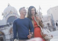Casal sorridente de mãos dadas e caminhando pela Praça de São Marcos em Veneza — Fotografia de Stock