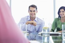 Uomo d'affari sorridente in riunione in ufficio moderno — Foto stock