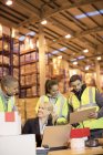 Бизнесвумен и рабочие разговаривают на складе — стоковое фото