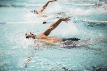 Swimmers racing in pool water — Stock Photo