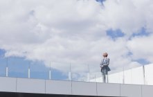 Empresário pensativo olhando para o céu na varanda do telhado — Fotografia de Stock